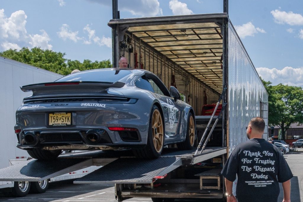 Car being loaded onto a truck for shipping.