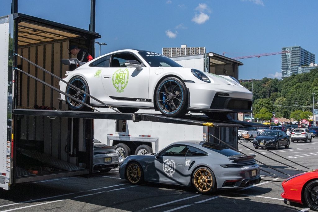 White car being loaded into a shipping container.