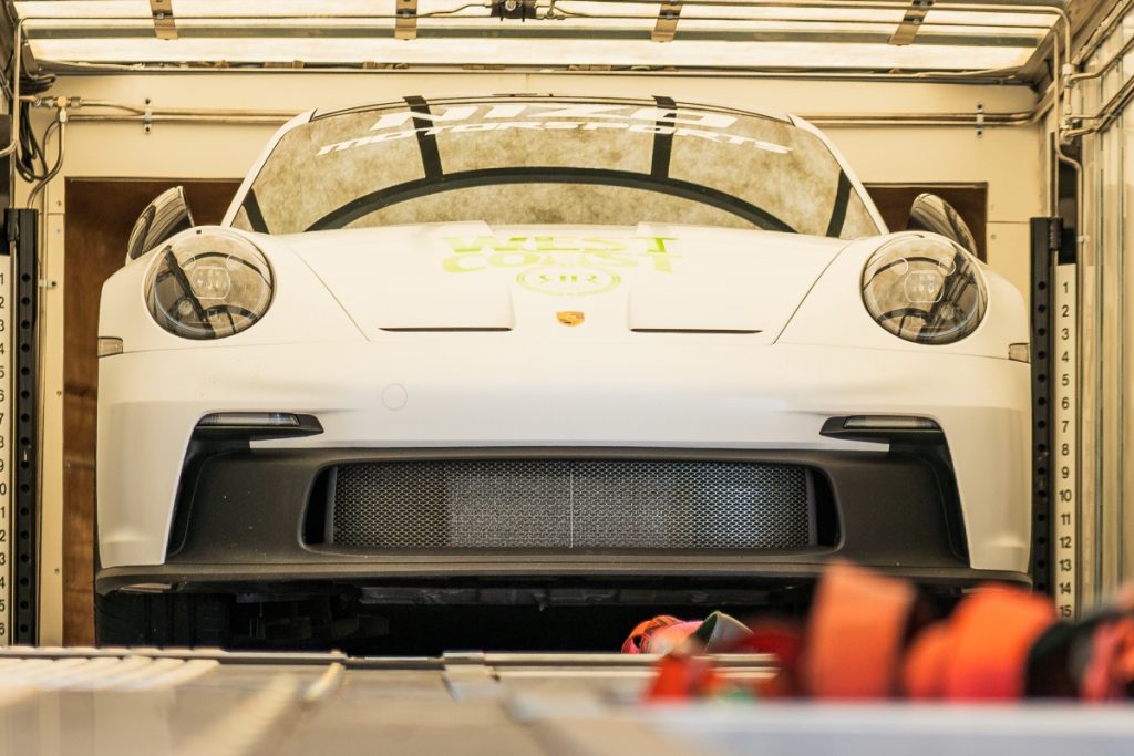 A car inside an enclosed transport trailer, ready for shipping.