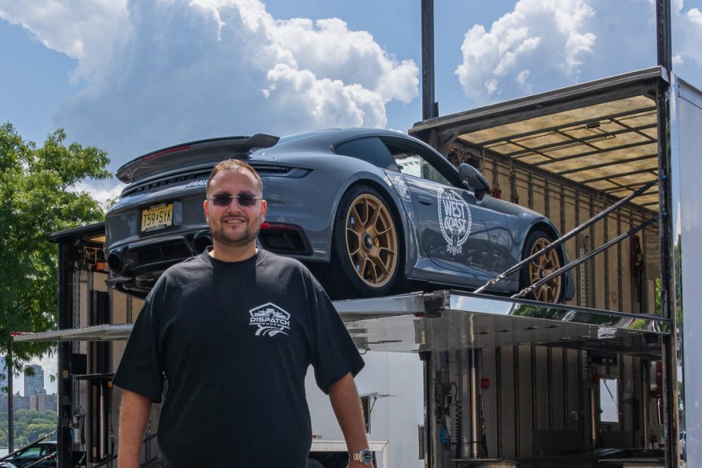 A Dispatch Dude standing next to a car that’s being loaded into a carrier.