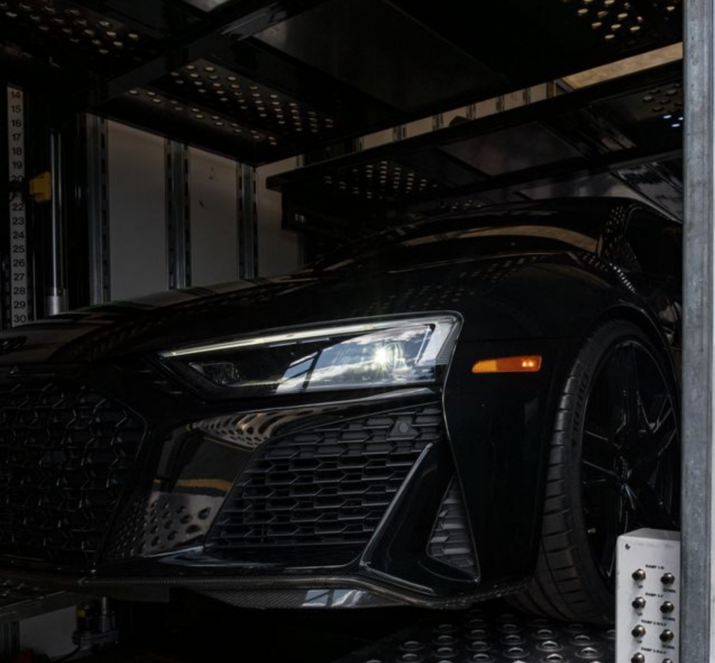 Audi in an enclosed transportation unit being protected from sun.