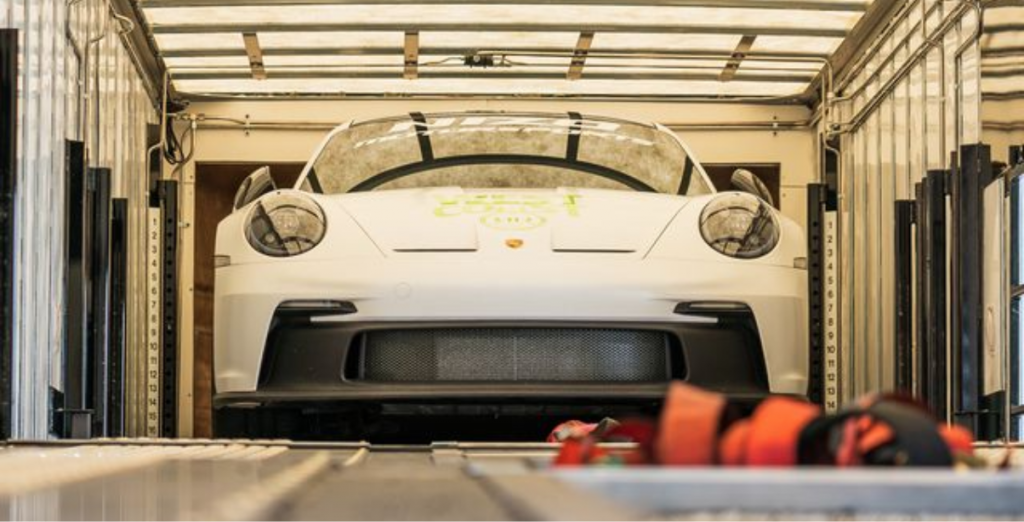 A luxury car being loaded into a trailer for a shipment over the mountains.