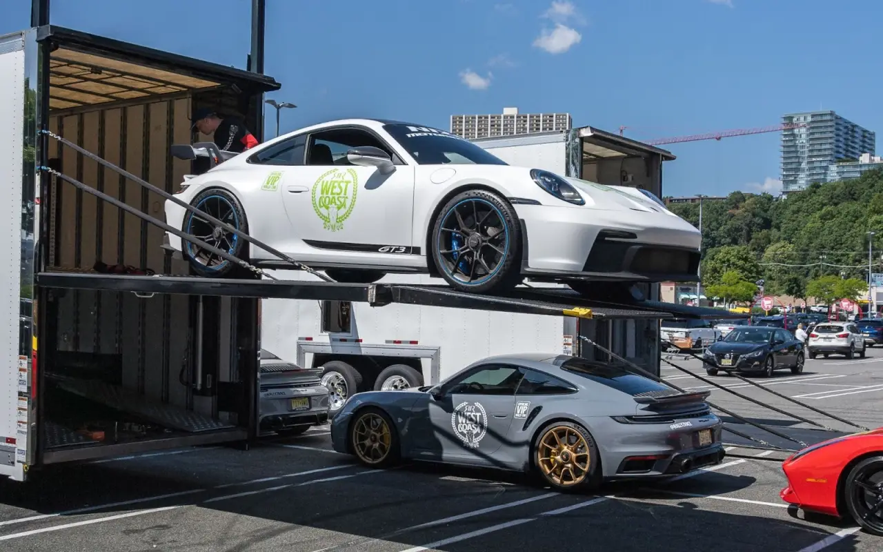 Luxury cars positioned for open and enclosed vehicle transport.