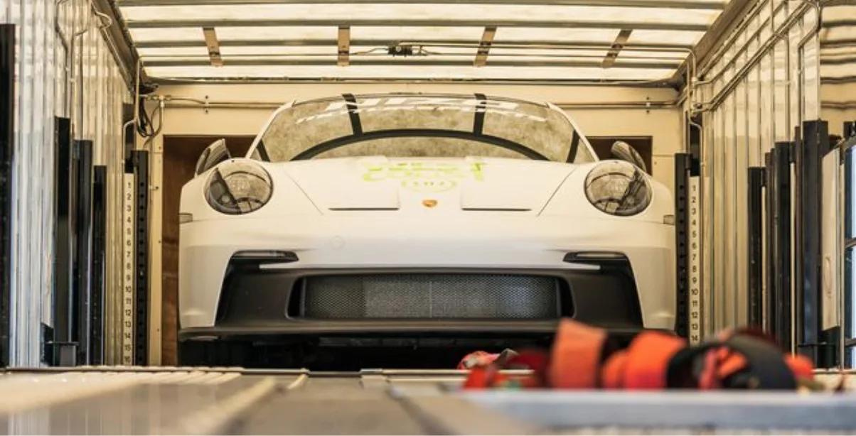 A luxury car being loaded into a trailer for a shipment over the mountains.