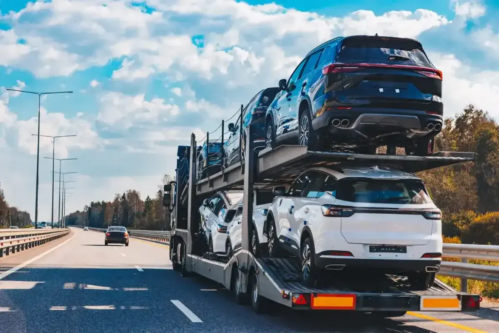 An open car carrier on a divided highway.