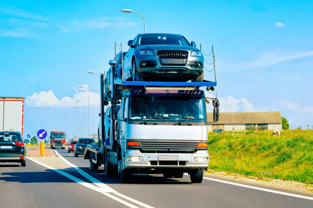 A car carrier truck transporting vehicles on a highway, illustrating vehicle transport logistics.